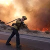 Lính cứu hỏa nỗ lực dập lửa cháy rừng tại thung lũng Simi, California, Mỹ ngày 12/11. (Nguồn: THX/TTXVN) 