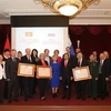 Đại sứ Ngô Đức Mạnh chụp ảnh lưu niệm với đại diện 3 trường được tặng thưởng Huân chương Hữu nghị. (Ảnh: Dương Trí/TTXVN) 