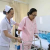Bệnh nhân Trần Thị Kim Anh (bị gãy chân) đang được hỗ trợ vận động tại Bệnh viện Sài Gòn ITO Phú Nhuận. (Ảnh: Đinh Hằng/TTXVN) 