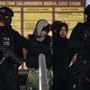 Nghi phạm Đoàn Thị Hương (giữa) được cảnh sát Malaysia áp giải rời Tòa án tối cao Shah Alam, ngoại ô Kuala Lumpur ngày 16/8/2018. (Nguồn: AFP/TTXVN) 