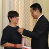 Đại sứ Việt Nam tại Cuba Nguyễn Trung Thành gắn Huân chương Hữu nghị cho bà Jehanne Roccas. (Ảnh: Vũ Lê Hà/TTXVN) 