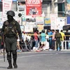 Lực lượng an ninh Sri Lanka gác gần một cửa hàng bị đập phá trong vụ đụng độ nhằm vào người Hồi giáo ở Minuwangoda ngày 14/5. (Nguồn: AFP/TTXVN) 