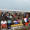 Người di cư trong hành trình đến Mỹ chờ đợi để đi qua khu vực biên giới từ Ciudad Tecun Uman, Guatemala, tới Ciudad Hidalgo, Mexico, ngày 21/10/2018. (Nguồn: AFP/TTXVN) 