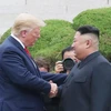 Tổng thống Mỹ Donald Trump (trái) bắt tay nhà lãnh đạo Triều Tiên Kim Jong-un (phải) trong cuộc gặp ở làng đình chiến Panmunjom tại Khu phi quân sự (DMZ) chiều 30/6/2019. (Nguồn: Yonhap/TTXVN) 