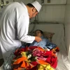 Bác sỹ thăm khám cho bệnh nhân Nguyễn Thị Bạc sau phẫu thuật. (Nguồn: TTXVN) 