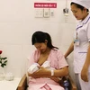 Sản phụ được hướng dẫn cách cho bé bú đúng cách trong một giờ sau khi sinh. (Nguồn: TTXVN) 