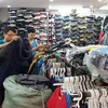 Lực lượng quản lý thị trường kiểm tra, phát hiện nhiều sản phẩm giả thương hiệu The North Face tại cửa hàng kinh doanh quần áo, giầy dép số 62 Lò Sũ, quận Hoàn Kiếm. (Ảnh: Trần Việt/TTXVN) 