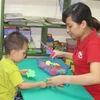 Giáo viên can thiệp, trị liệu và hỗ trợ hòa nhập cho trẻ tự kỷ ở Ninh Bình. (Ảnh: Thùy Dung/TTXVN) 
