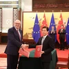 Ủy viên Phát triển nông nghiệp và nông thôn của EU Phil Hogan (trái) và Bộ trưởng Thương mại Trung Quốc Chung Sơn (phải) trao đổi văn kiện sau lễ ký thỏa thuận tại Bắc Kinh ngày 6/11/2019. (Nguồn: AFP/TTXVN) 