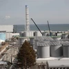 Lò phản ứng số 4 (trái) và các bể chứa nước nhiễm xạ tại nhà máy điện hạt nhân Fukushima Daiichi ở tỉnh Fukushima, Nhật Bản. (Nguồn: AFP/TTXVN) 