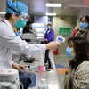 Nhân viên y tế Trung Quốc kiểm tra thân nhiệt một người dân tại bệnh viện ở Phúc Châu, thủ phủ tỉnh miền Đông Nam Phúc Kiến, ngày 31/1/2020. (Nguồn: AFP/TTXVN) 
