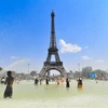Người dân tránh nóng bên vòi phun nước tại Paris, Pháp, ngày 25/7/2019. (Nguồn: THX/TTXVN) 