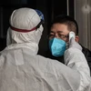 Kiểm tra thân nhiệt một hành khách nhằm ngăn chặn sự lây lan của dịch viêm đường hô hấp cấp do virus corona chủng mới (2019-nCoV) tại nhà ga đường sắt ở Bắc Kinh, Trung Quốc ngày 27/1/2020. (Nguồn: THX/TTXVN) 