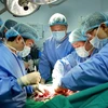 Kíp phẫu thuật của Bệnh viện Quân y 103 thực hiện thành công ca ghép phổi đầu tiên từ người sống. (Ảnh: Dương Ngọc/TTXVN)