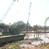 Thi công đắp đập tạm ngăn mặn trên sông Ba Lai. (Ảnh: Công Trí/TTXVN) 