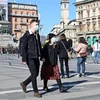 Khách thăm quan đeo khẩu trang phòng dịch COVID-19 tại quảng trường del Duomo, Milan, Italy ngày 24/2/2020. (Nguồn: AFP/TTXVN) 