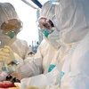 Nhóm nghiên cứu phân tích mẫu bệnh phẩm của bệnh nhân nhiễm virus SARS-CoV-2 tại phòng thí nghiệm ở Hà Nam, Trung Quốc ngày 4/2/2020. (Nguồn: THX/TTXVN) 