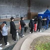 Các nhân viên một trung tâm chăm sóc khách hàng bị nghi nhiễm COVID-19 xếp hàng chờ lấy mẫu xét nghiệm bệnh phẩm tại khu y tế dựng tạm ở Seoul, ngày 10/3/2020. (Nguồn: Yonhap/TTXVN) 