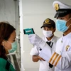 Nhân viên an ninh kiểm tra thân nhiệt người dân trước cửa một tòa nhà nhằm ngăn chặn sự lây lan của dịch COVID-19 tại Bangkok, Thái Lan ngày 16/3/2020. (Nguồn: AFP/TTXVN) 