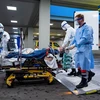 Nhân viên tế chuyển bệnh nhân mắc COVID-19 vào một bệnh viện ở Ulm, Tây Nam Đức, ngày 29/3/2020. (Nguồn: AFP/TTXVN) 