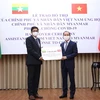 Thứ trưởng Bộ Ngoại giao Nguyễn Quốc Dũng trao tiền hỗ trợ của Chính phủ và nhân dân Việt Nam cho Đại sứ Myanmar tại Việt Nam Kyaw Soe Win. (Ảnh: Dương Giang/TTXVN) 
