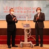 Ông Trần Ngọc Phúc (phải) bàn giao máy thở cho Đại sứ Vũ Hồng Nam. (Ảnh: Đức Thịnh/TTXVN)