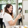 Khách hàng trải nghiệm một mẫu điện thoại thông minh của Samsung tại Sydney, Australia ngày 18/2/2020. (Nguồn: Yonhap/TTXVN) 