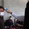 Nhân viên y tế kiểm tra thân nhiệt nhằm ngăn chặn sự lây lan của dịch COVID-19 tại Idlib, Syria, ngày 27/4/2020. (Nguồn: AFP/TTXVN) 