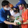 Anh Hoàng Văn Thanh, Phó Bí thư tỉnh đoàn Thanh Hóa trao gạo hỗ trợ cho các công nhân có hoàn cảnh khó khăn. (Ảnh: Nguyễn Nam/TTXVN) 