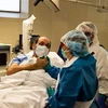Nhân viên y tế động viên tinh thần bệnh nhân mắc COVID-19 tại một bệnh viện ở Barcelona, Tây Ban Nha ngày 7/5/2020. (Nguồn: THX/TTXVN) 