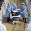 Nhân viên y tế chuyển nạn nhân nhiễm virus corona tới điều trị tại bệnh viện dã chiến Hỏa Thần Sơn ở Vũ Hán, tỉnh Hồ Bắc, Trung Quốc, ngày 4/2/2020. (Nguồn: THX/TTXVN) 