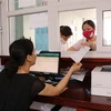 Người dân giao dịch tại quầy Bảo hiểm xã hội tỉnh Bắc Ninh. (Ảnh: Đinh Văn Nhiều/TTXVN) 