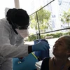 Nhân viên y tế lấy mẫu dịch xét nghiệm COVID-19 cho người dân tại Miami, bang Florida, Mỹ ngày 16/4/2020. (Nguồn: AFP/TTXVN) 