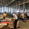 Sản xuất đồ gỗ tại Công ty Trách nhiệm hữu hạn Một thành viên Triệu Phú Lộc, thị xã Tân Uyên. (Ảnh: Chí Tưởng/TTXVN)