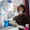 Nhân viên y tế lấy mẫu dịch xét nghiệm COVID-19 cho người dân tại Hong Kong, Trung Quốc ngày 19/7/2020. (Nguồn: AFP/TTXVN) 