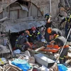 Lực lượng cứu hộ tìm kiếm nạn nhân tại hiện trường vụ nổ. (Nguồn: AFP/TTXVN) 