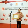 Vụ trưởng Vụ Đông Nam Á, Bộ Ngoại giao Indonesia Denny Abdi trao tượng trưng giải khuyến khích của cuộc thi. (Ảnh: Hữu Chiến/TTXVN) 
