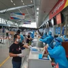 Nhân viên mặt đất của Hãng hàng không Vietjet phát quần áo bảo hộ miễn phí cho hành khách rời Đà Nẵng. (Nguồn: Vietnam+) 