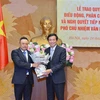 Chủ nhiệm Văn phòng Quốc hội Nguyễn Hạnh Phúc (bên phải) trao Quyết định của Bộ Chính trị, Nghị quyết của Ủy ban Thường vụ Quốc hội và tặng hoa chúc mừng ông Trần Sỹ Thanh. (Nguồn: TTXVN)
