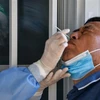 Nhân viên y tế lấy mẫu dịch xét nghiệm COVID-19 cho người dân tại Vũ Hán, tỉnh Hồ Bắc, Trung Quốc, ngày 3/9/2020. (Nguồn: AFP/TTXVN) 