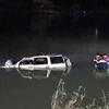 Lực lượng cứu hộ trục vớt chiếc xe ôtô 7 chỗ cùng các thi thể nạn nhân trong đêm. (Nguồn: TTXVN phát) 