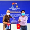 Phó Chủ tịch công ty ViMariel, chi nhánh của Viglacera tại Cuba Nguyễn Ngọc Anh trao tặng tượng trưng 100 tấn gạo cho Thứ trưởng Y tế Cuba Luis Fernando Navarro Martínez. (Ảnh: Lê Hà/TTXVN) 