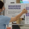 Một nhân viên y tế dán thông báo tạm dừng chương trình tiêm chủng cúm trước cổng một bệnh viện ở Sejong, Hàn Quốc, ngày 22/9/2020. (Ảnh: Reuters / Yonhap) 