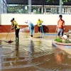 Cán bộ, giáo viên cùng các lực lượng tình nguyện viên đã được huy động để khẩn trương dọn dẹp vệ sinh, khắc phục hậu quả mưa lũ tại Trường Tiểu học và Trung học cơ sở Phú Hải (thành phố Đồng Hới). (Ảnh: Võ Dung/TTXVN) 