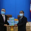 Đại sứ đặc mệnh toàn quyền Việt Nam tại Campuchia Vũ Quang Minh bàn giao quà tặng khẩu trang tới ông Kem Sambath, Ủy viên Trung ương Đảng, Phó Trưởng Ban Đối ngoại Trung ương CPP. (Ảnh: Hùng Vũ/TTXVN) 