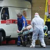 Nhân viên y tế chuyển bệnh nhân nhiễm COVID-19 tới bệnh viện ở Saint Petersburg, Nga. (Nguồn: AFP/TTXVN) 