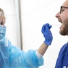 Nhân viên y tế lấy mẫu dịch xét nghiệm COVID-19 cho người dân tại Lund, Thụy Điển. (Nguồn: AFP/TTXVN) 