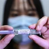 Nhân viên Tập đoàn dược quốc gia Trung Quốc (Sinopharm) giới thiệu mẫu vắcxin phòng dịch COVID-19 tại nhà máy của Tập đoàn ở Bắc Kinh ngày 10/4/2020. (Nguồn: THX/TTXVN) 