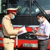 Tổ công tác của Trạm Cảnh sát giao thông Tam Điệp, Phòng Cảnh sát giao thông Công an tỉnh Ninh Bình kiểm tra một xe chở khách trên tuyến Quốc lộ 1A. (Ảnh: Đức Phương/TTXVN) 