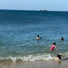 Du khách vui chơi, tắm biển Cà Ná, huyện Thuận Nam. (Ảnh: Công Thử/TTXVN) 